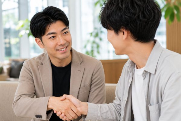 カフェスペースで握手する男性
