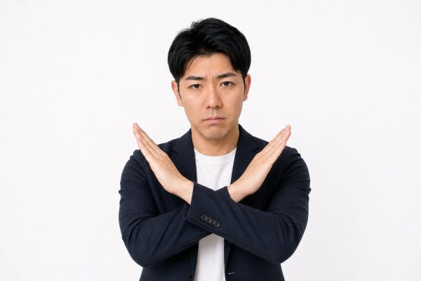 腕でバツを作る男性(白背景)
