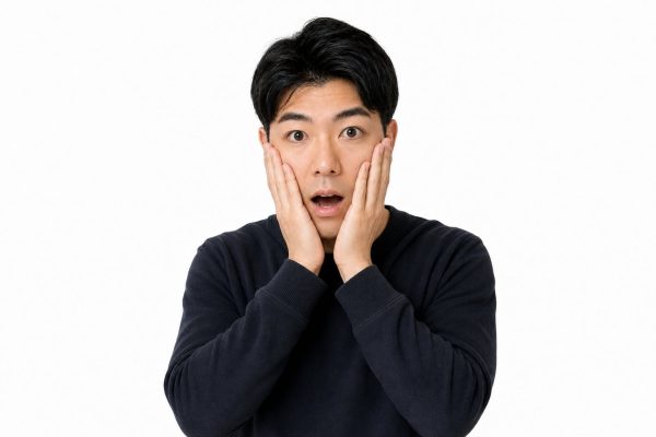 頬に手を当てて驚く男性(白背景)