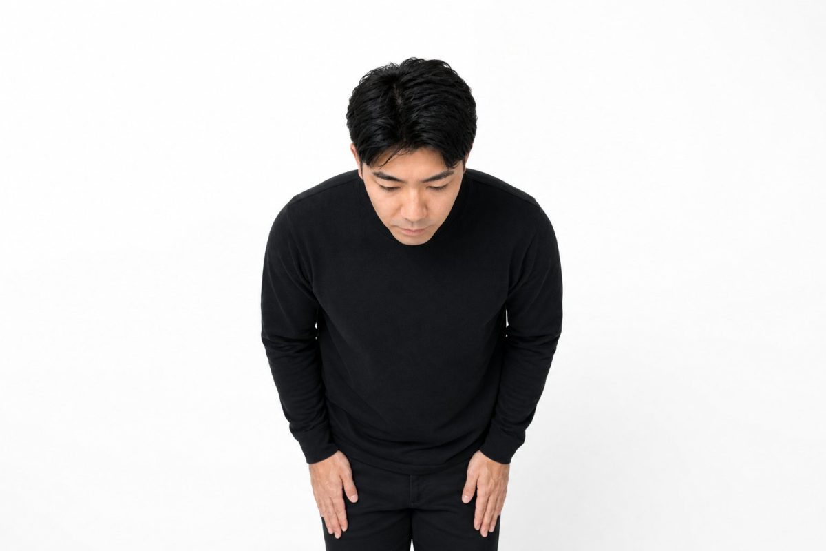 謝罪のお辞儀をする男性(白背景)