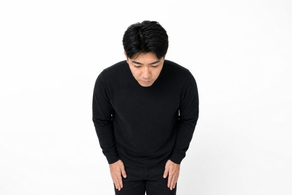謝罪のお辞儀をする男性(白背景)