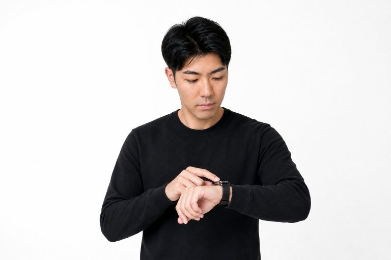 腕時計を見て焦る男性(白背景)