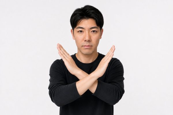 腕でNGサインを出す男性(白背景)