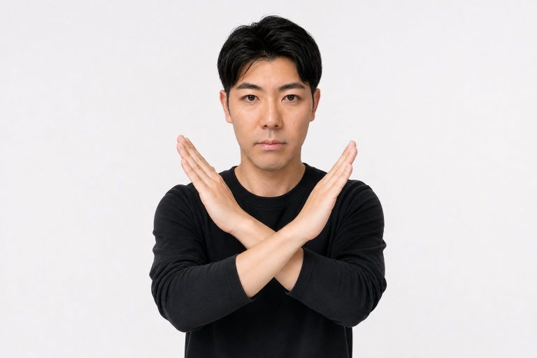腕でNGサインを出す男性(白背景)