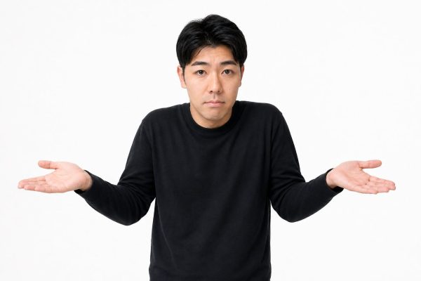 軽く肩をすくめる男性(白背景)