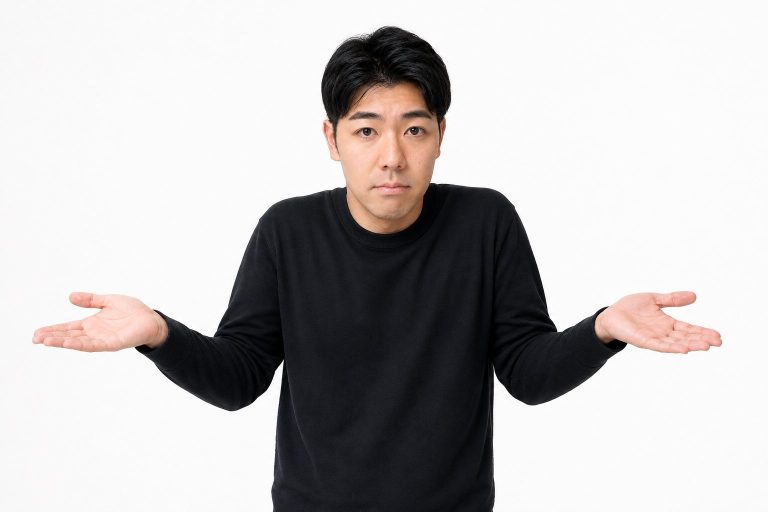 軽く肩をすくめる男性(白背景)