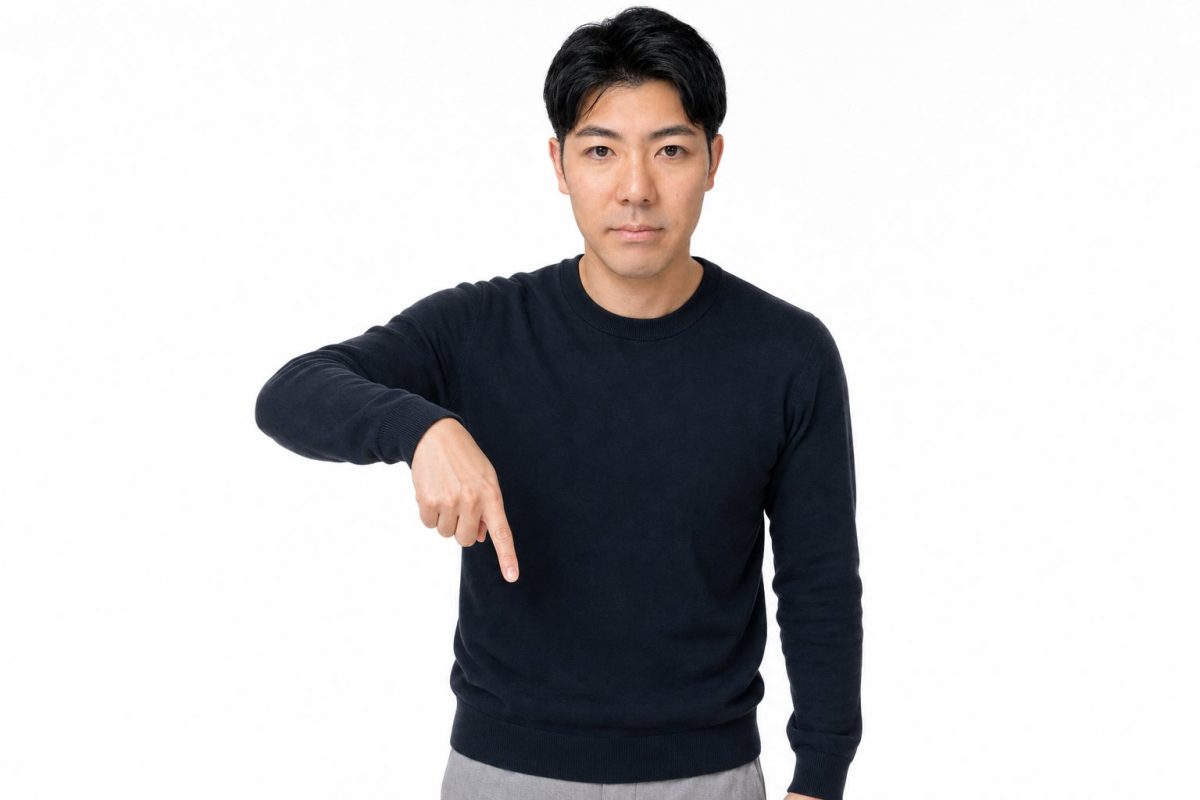 下を指差して説明する男性(白背景)