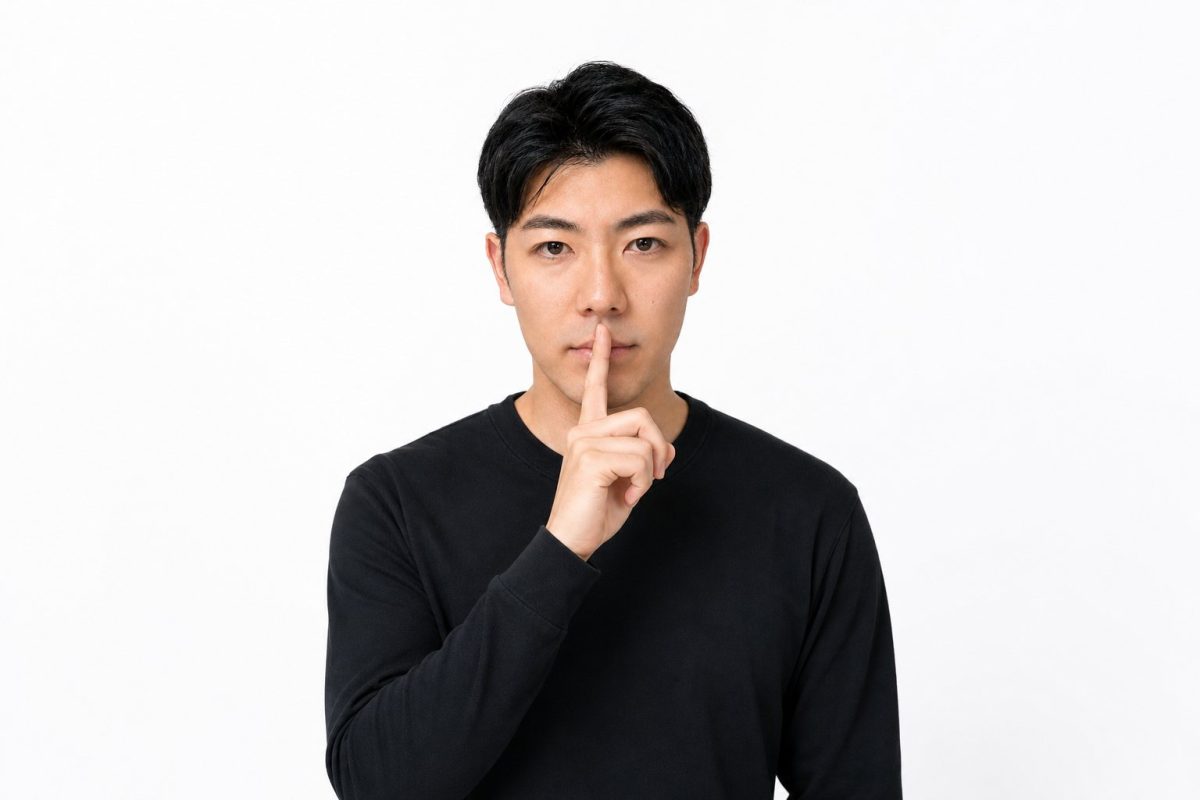 口元に指を当てて静かにと伝える男性(白背景)