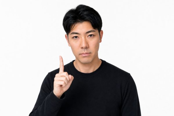 人差し指を立てて注意を促す男性(白背景)