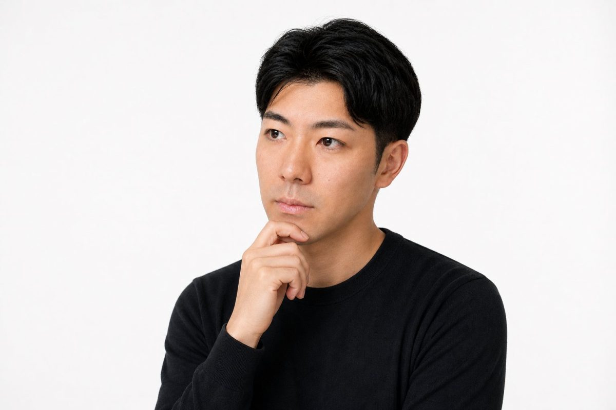 顎に手を当てて横を向いて考える男性(白背景)