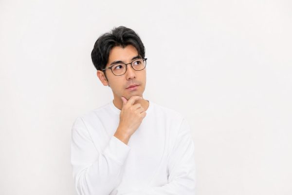 じっくり考え込む男性(白背景)