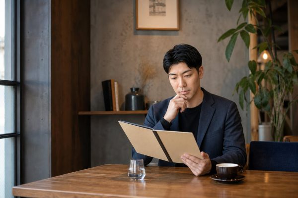 カフェでメニューを検討する男性