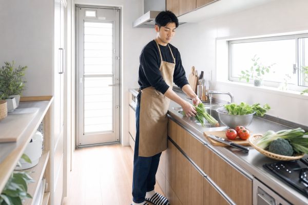 キッチンで野菜を洗う男性