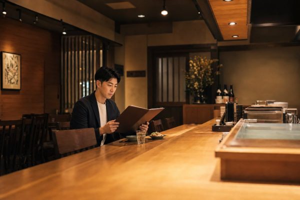 居酒屋でメニューを選ぶ男性
