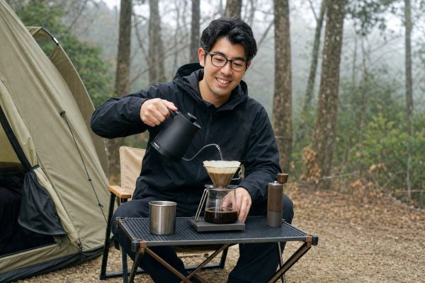 キャンプでコーヒーを淹れる男性