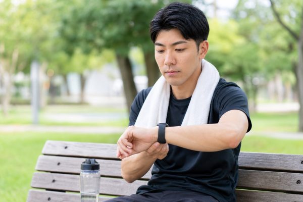 運動後に脈拍を測る男性