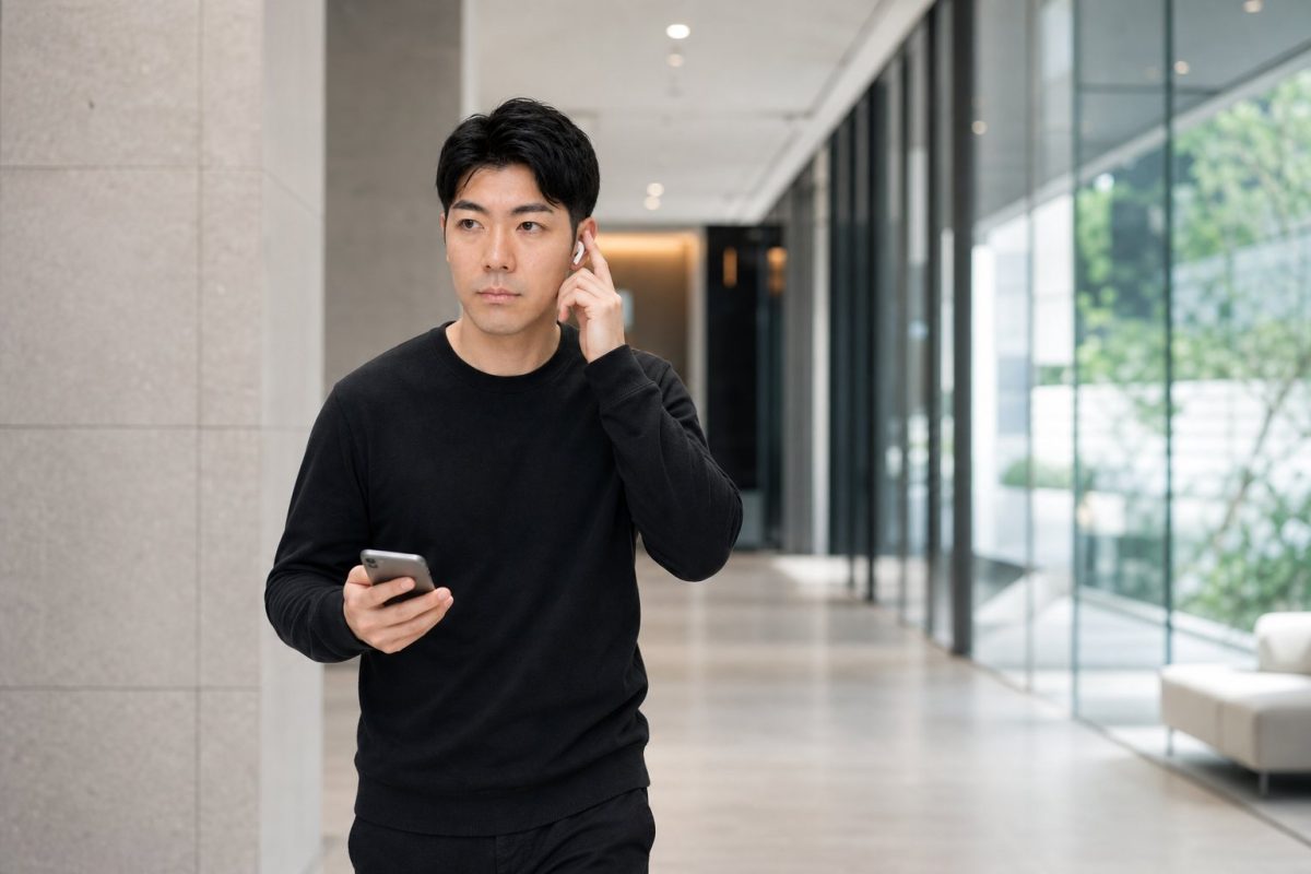 イヤホンで通話しながら歩く男性