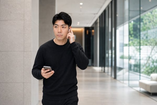 イヤホンで通話しながら歩く男性