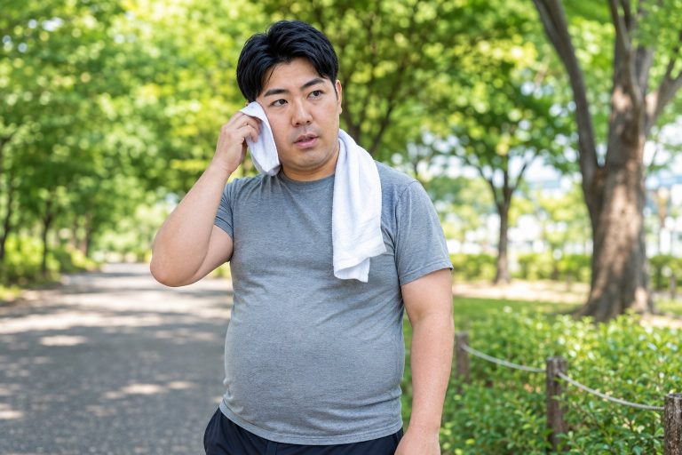 ウォーキングで汗を拭う男性