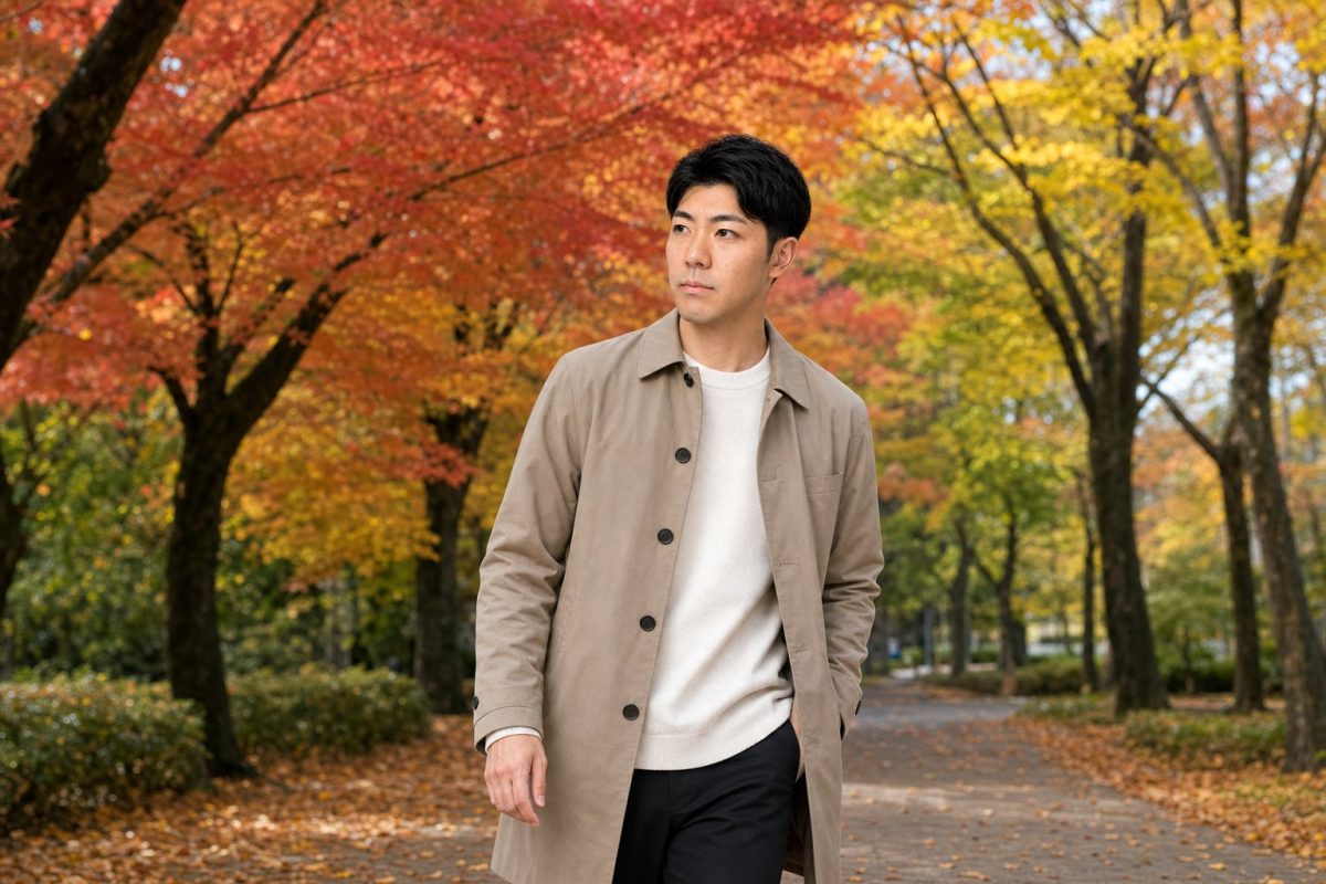 紅葉の中をコートで散策する男性