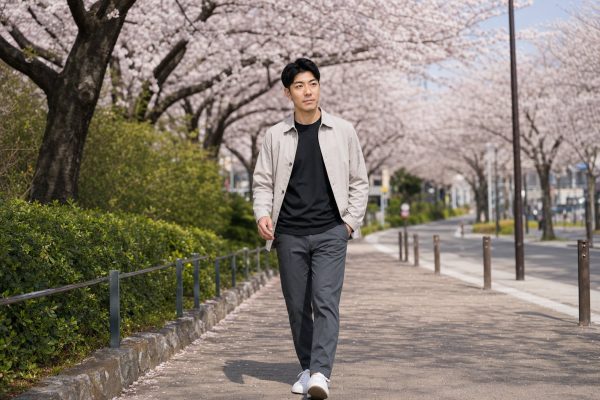 桜並木を歩く男性