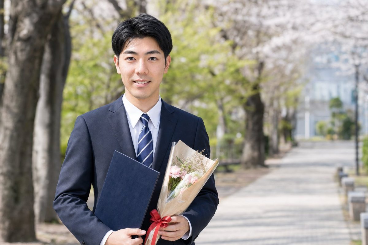 花束を手に卒業を祝う男性