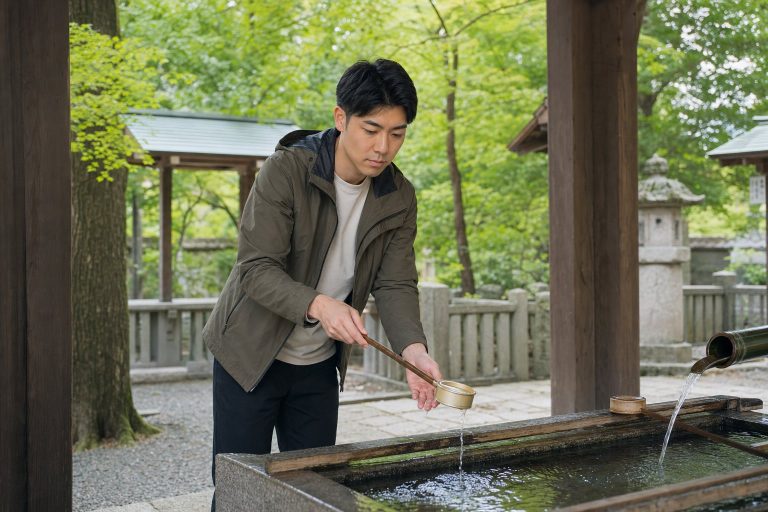 神社の手水舎で清める男性